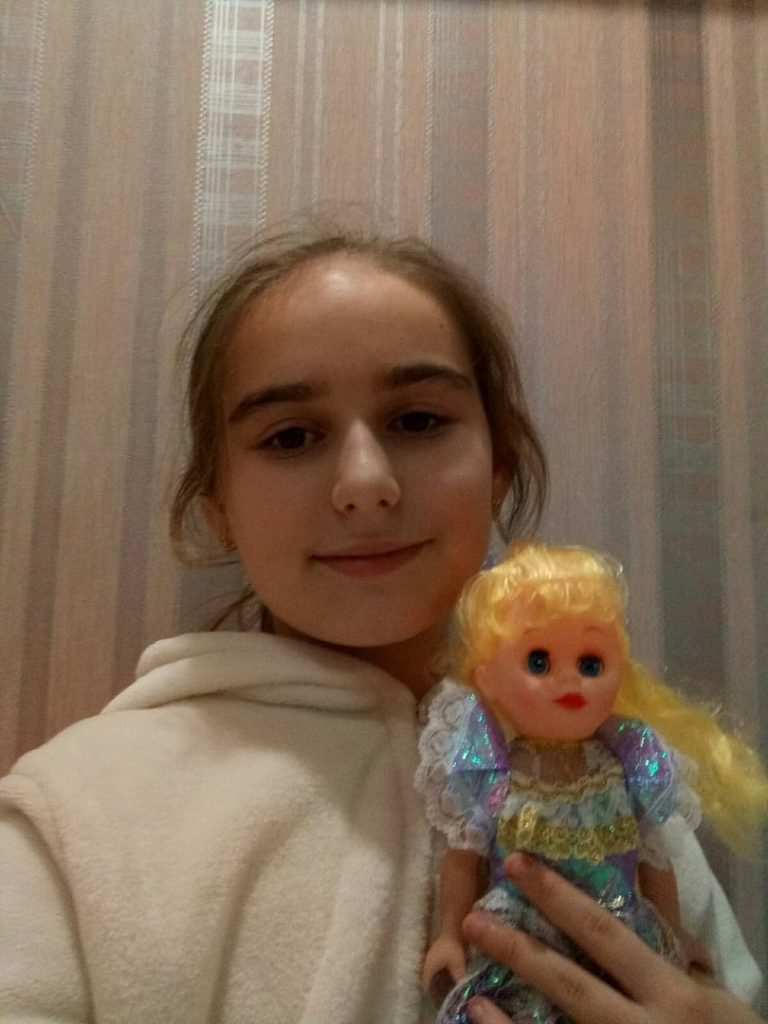 Kristina Papenkova, 10, z pěveckého souboru Eťud-Tais po předání panenky od LKŽ, Alčevsk, listopad 2019